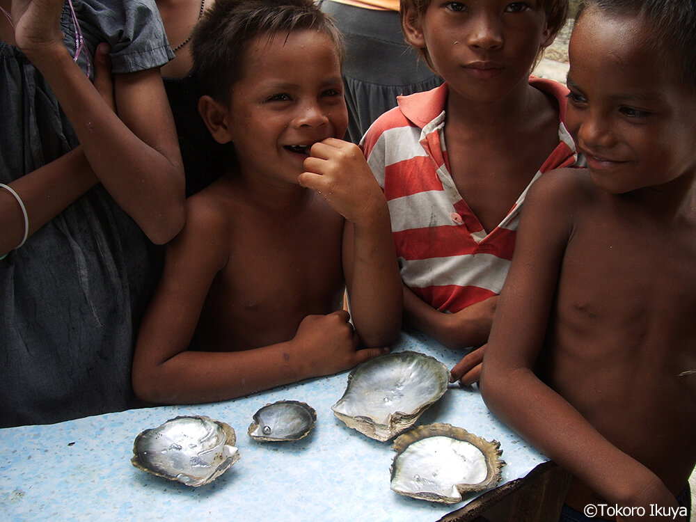 採集した黒蝶貝と真珠を前にしたサマ人の子供たち